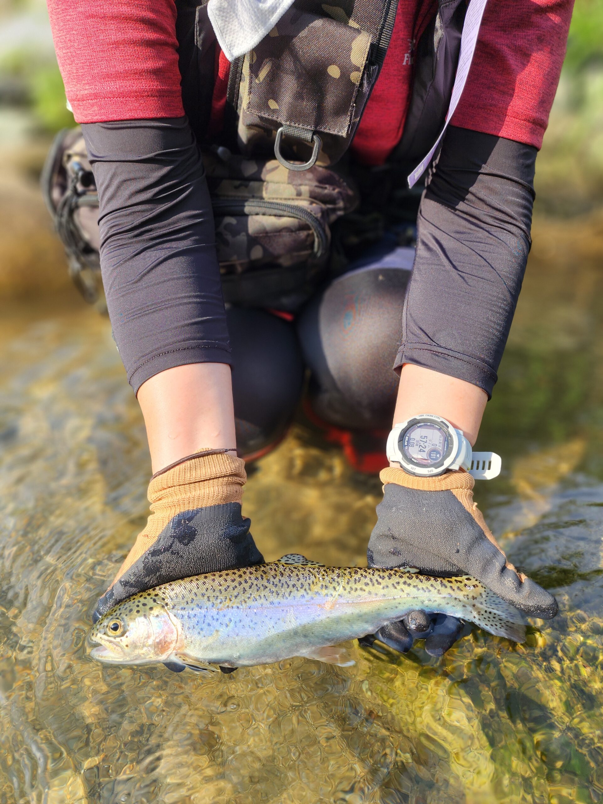 渓流釣り初体験の女性が、餌釣りで良型のニジマスを釣り上げた場面。初心者にもおすすめの体験ツアー。